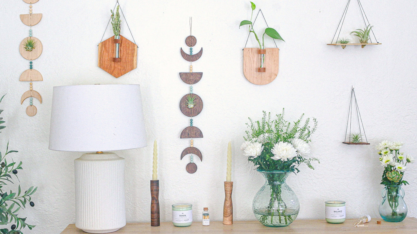 Wall of wood plant holders, candles, and vases with flowers.