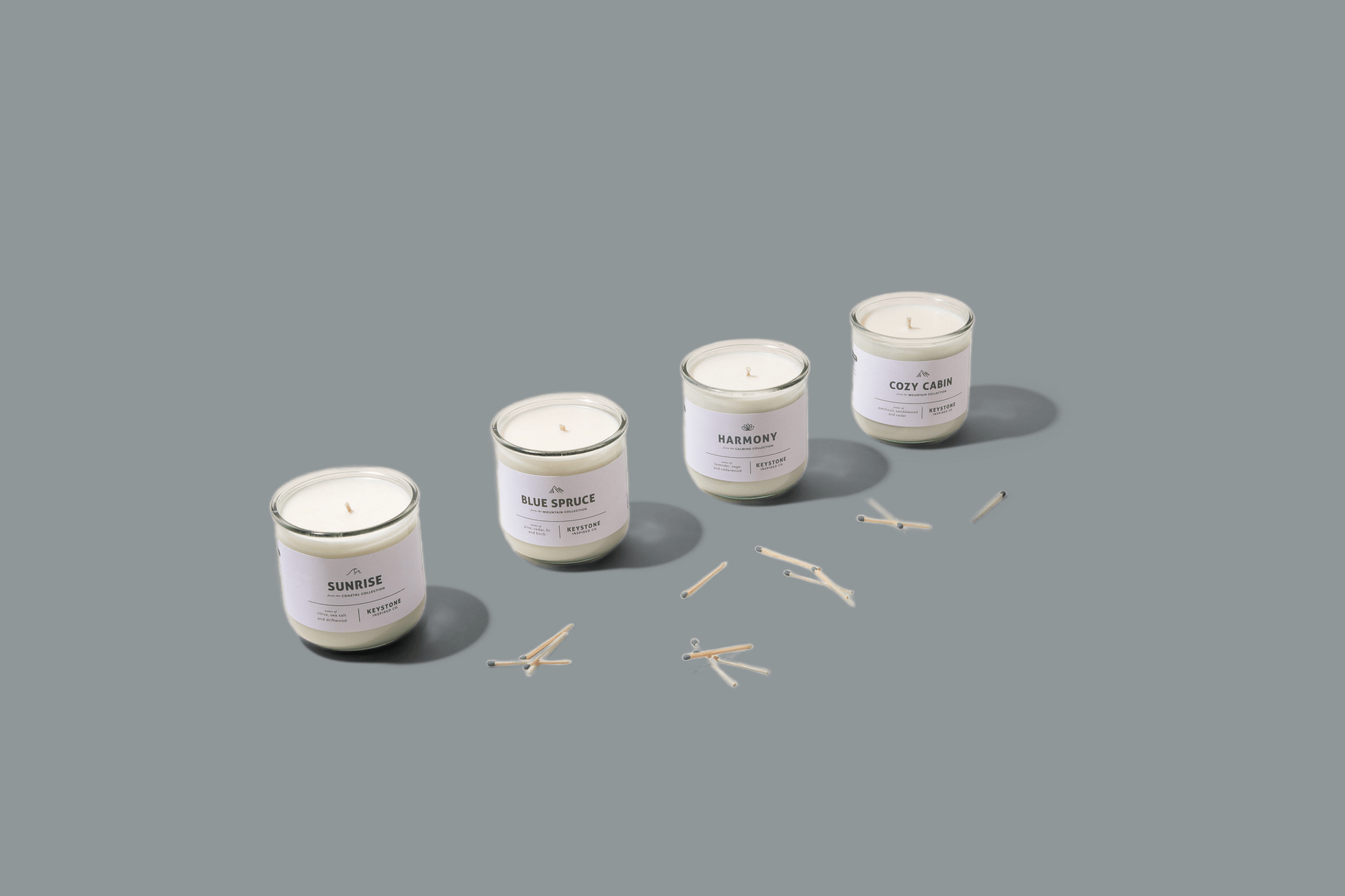 Four glass candles on a gray background